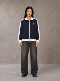 Model wearing the SM Insignia Jacket in Oxford Navy, front view.