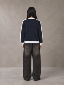 Model wearing the SM Insignia Jacket in Oxford Navy, rear view.