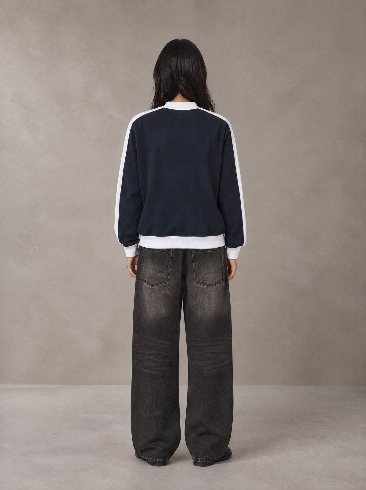 Model wearing the SM Insignia Jacket in Oxford Navy, rear view.