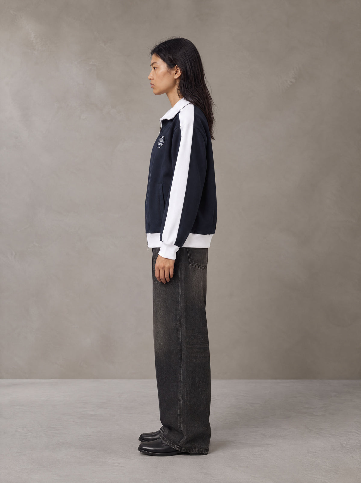 Model wearing the SM Insignia Jacket in Oxford Navy, side profile.