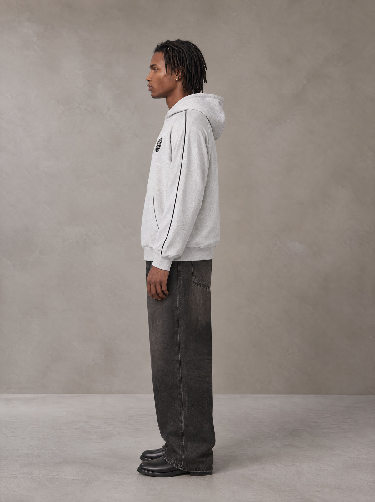 Model wearing the SM Insignia Parallel Hoodie in Floral Grey, side profile.