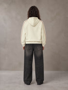 Model wearing the SM Insignia Parallel Hoodie in Classic Cream, rear view.