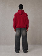 Model wearing the SM Insignia Parallel Hoodie in Carmine, rear view.