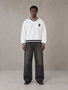 Model wearing the SM Insignia Sweatshirt in Lucent White, front view.