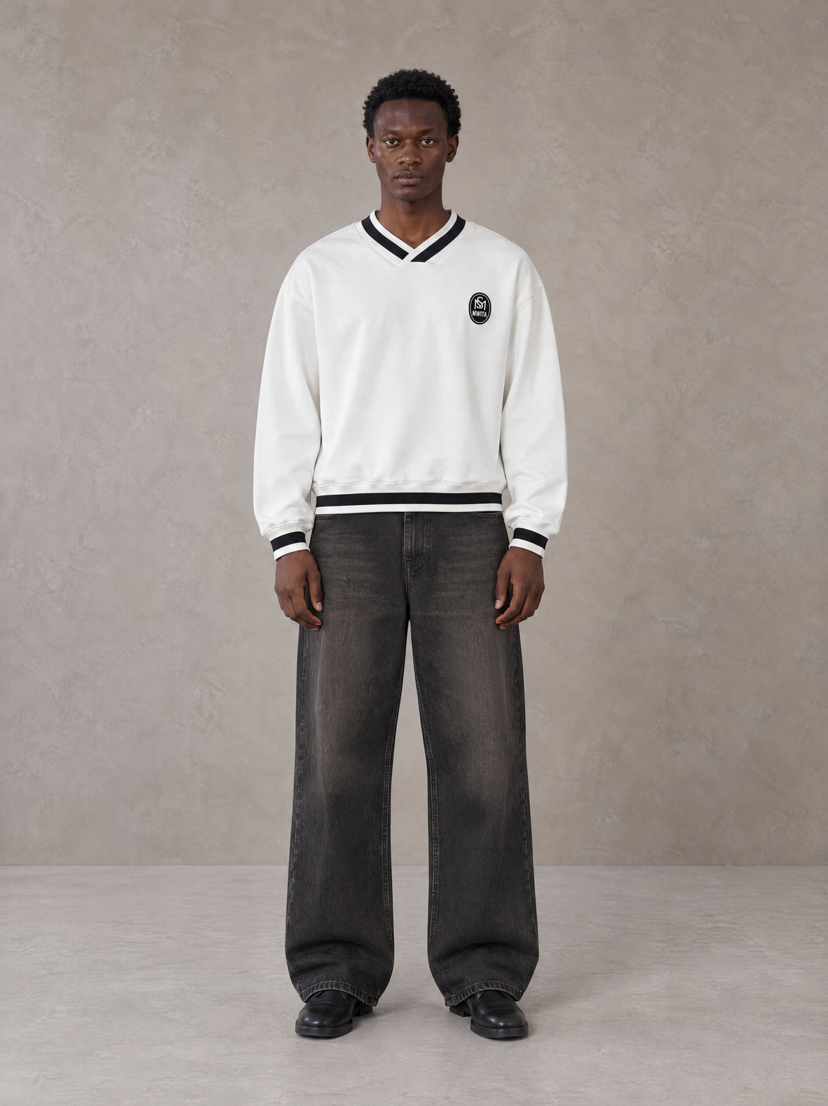 Model wearing the SM Insignia Sweatshirt in Lucent White, front view.