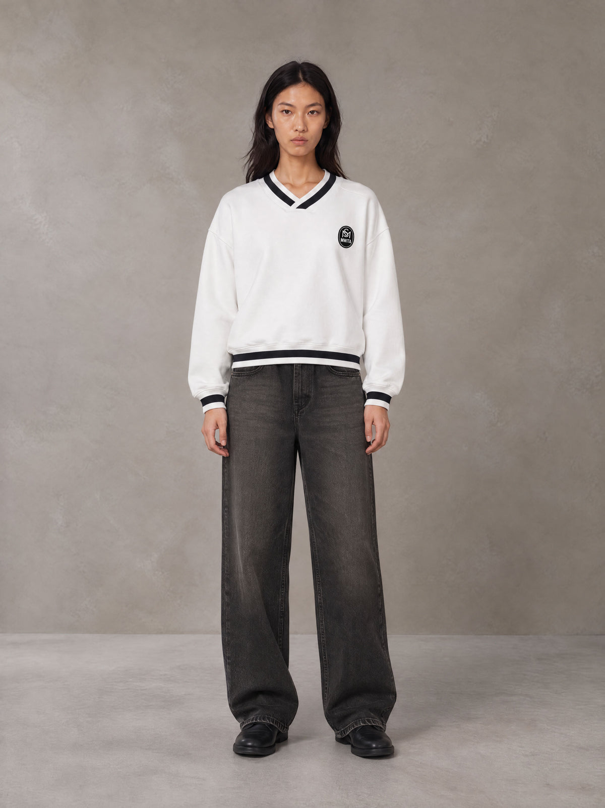 Model wearing the SM Insignia Sweatshirt in Lucent White, front view.