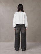Model wearing the SM Insignia Sweatshirt in Lucent White, rear view.