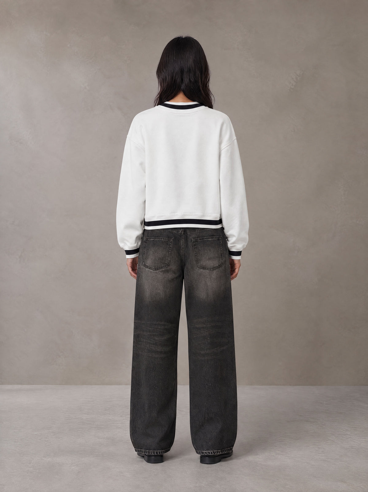 Model wearing the SM Insignia Sweatshirt in Lucent White, rear view.