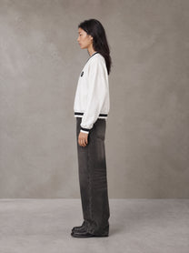 Model wearing the SM Insignia Sweatshirt in Lucent White, side profile.