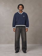 Model wearing the SM Insignia Sweatshirt in Oxford Navy, front view.