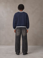 Model wearing the SM Insignia Sweatshirt in Oxford Navy, rear view.