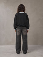 Model wearing the SM Insignia Sweatshirt in Midnight Black, rear view.