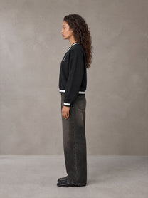 Model wearing the SM Insignia Sweatshirt in Midnight Black, side profile.