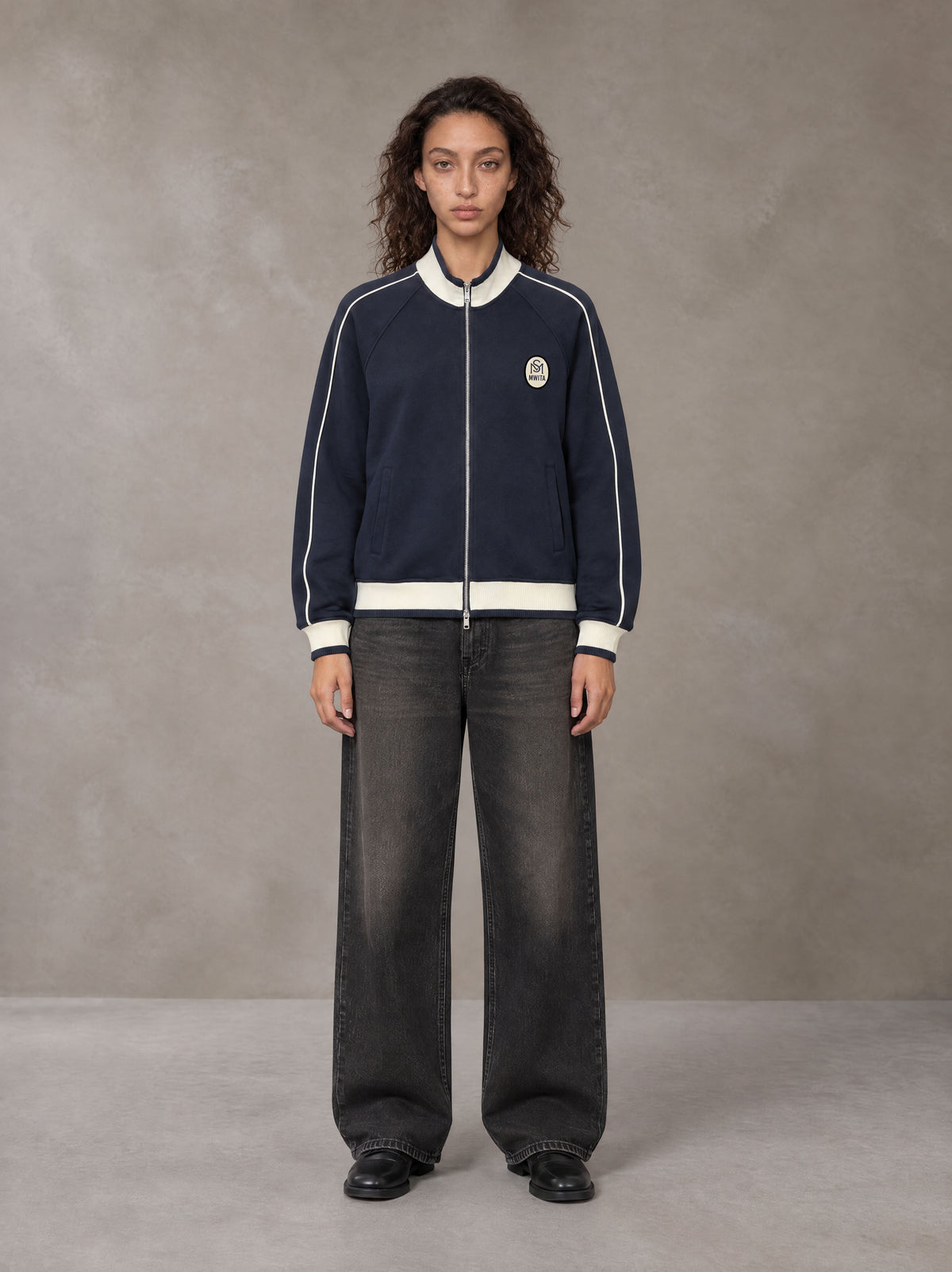 Model wearing the SM Insignia Trim Track Jacket in Oxford Navy, front view.
