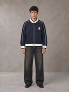 Model wearing the SM Insignia Trim Track Jacket in Oxford Navy, front view.