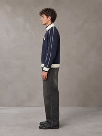 Model wearing the SM Insignia Trim Track Jacket in Oxford Navy, side profile.