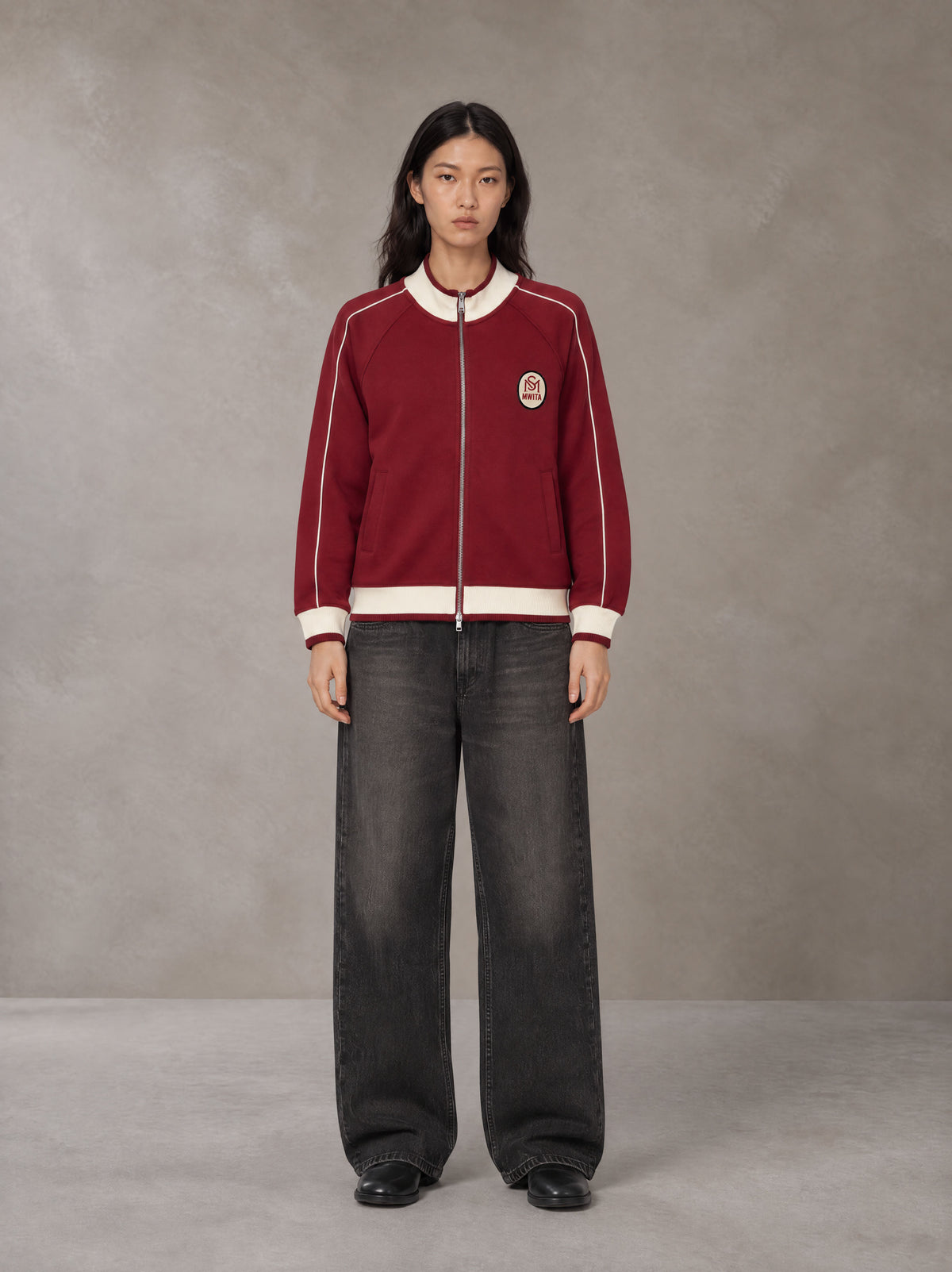 Model wearing the SM Insignia Trim Track Jacket in Carmine, front view.