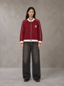 Model wearing the SM Insignia Trim Track Jacket in Carmine, front view.