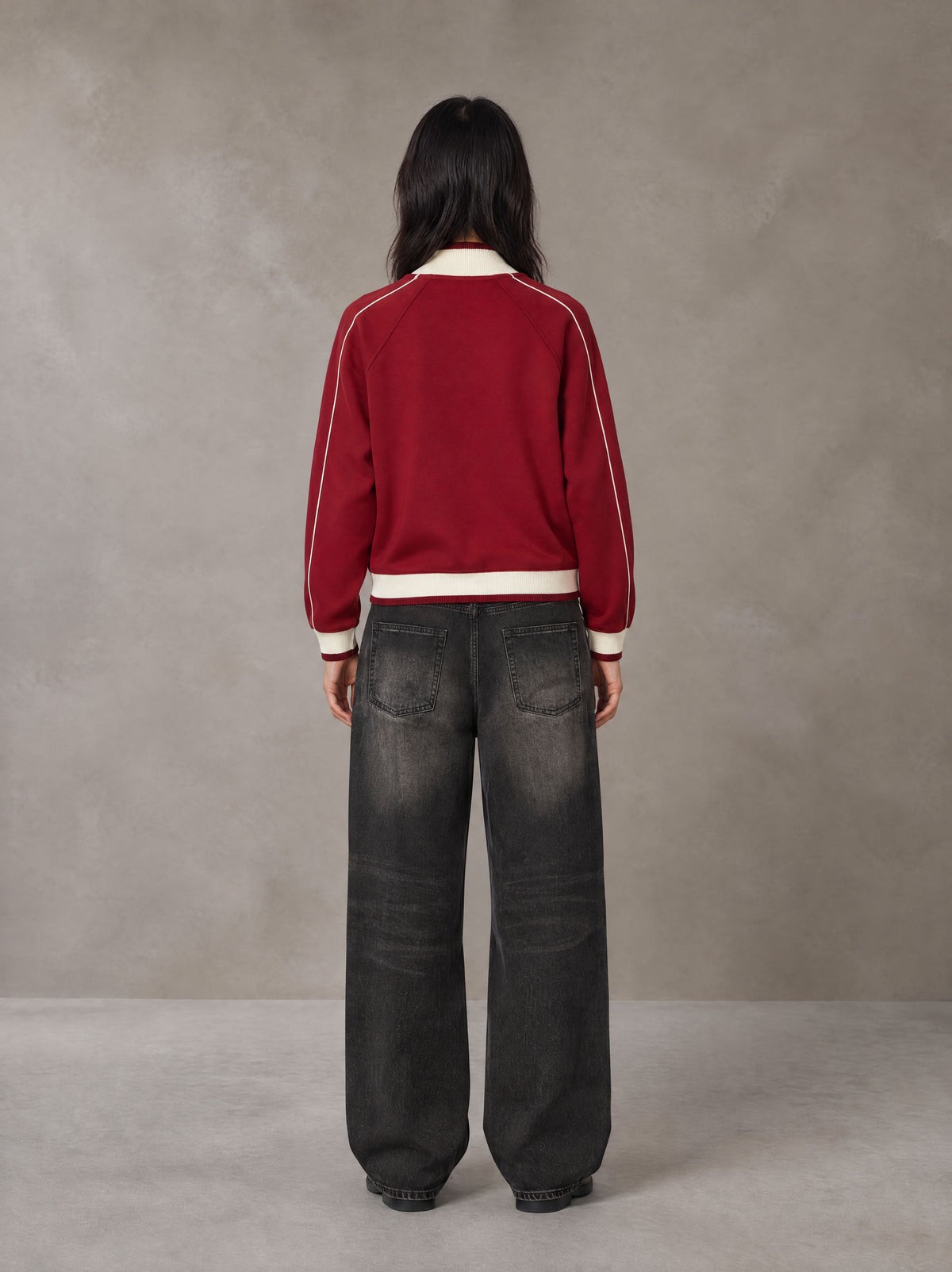 Model wearing the SM Insignia Trim Track Jacket in Carmine, rear view.