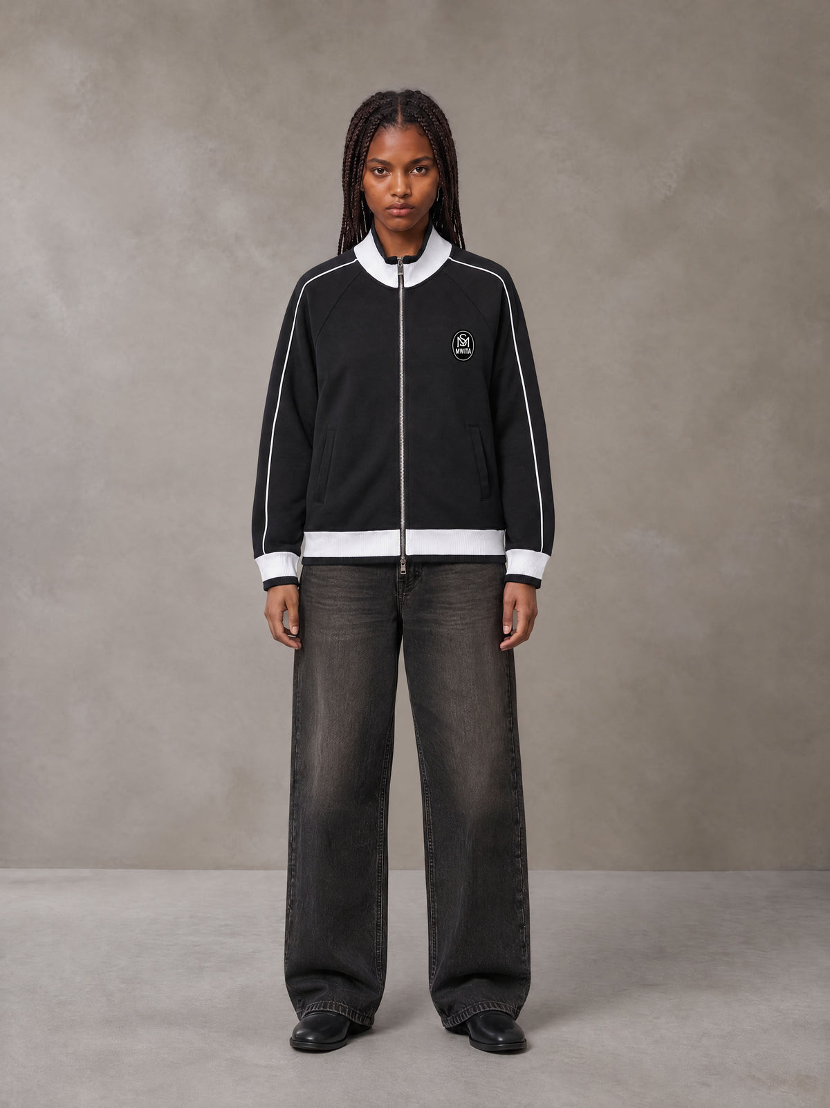 Model wearing the SM Insignia Trim Track Jacket in Midnight Black, front view.