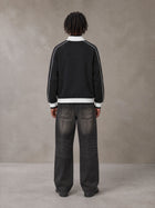 Model wearing the SM Insignia Trim Track Jacket in Midnight Black, rear view.