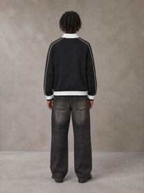 Model wearing the SM Insignia Trim Track Jacket in Midnight Black, rear view.