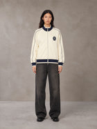 Model wearing the SM Insignia Trim Track Jacket in Classic Cream, front view.