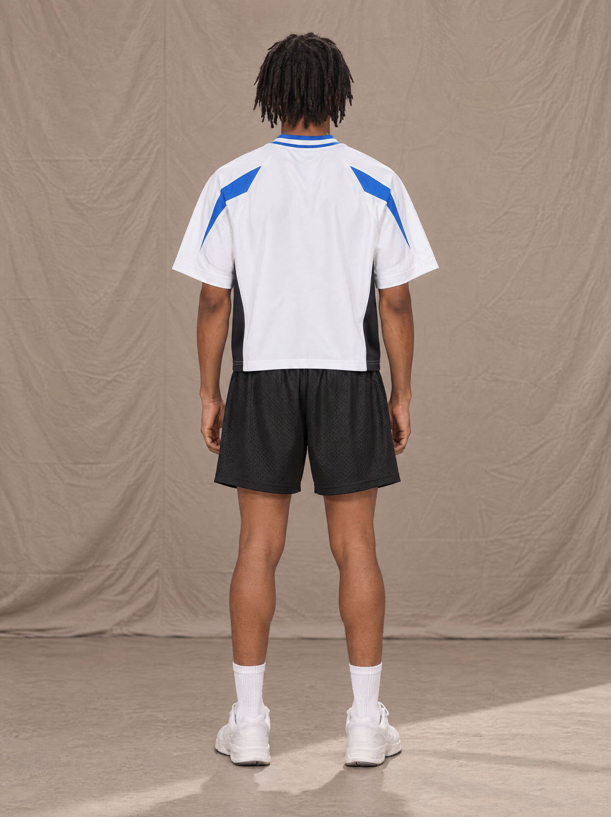 Model wearing the SM Motion Vector Jersey in Lucent White, rear view.