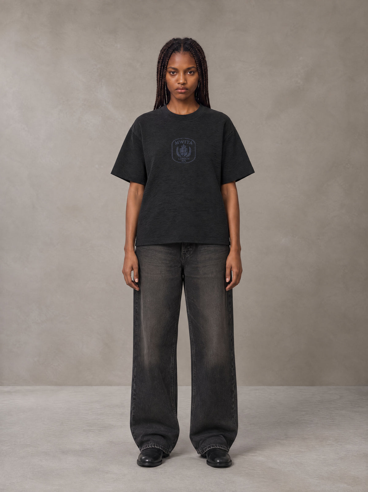 Model wearing the SM Jacquard Knitted Royal Emblem Knitted T-shirt in Midnight Black, front view.