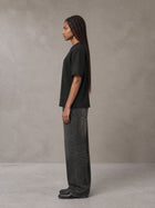 Model wearing the SM Jacquard Knitted Royal Emblem Knitted T-shirt in Midnight Black, side profile.