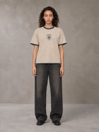 Model wearing the SM Jacquard Knitted Royal Emblem Knitted T-shirt in Oatmeal Cookie, front view.