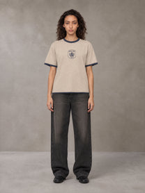 Model wearing the SM Jacquard Knitted Royal Emblem Knitted T-shirt in Oatmeal Cookie, front view.