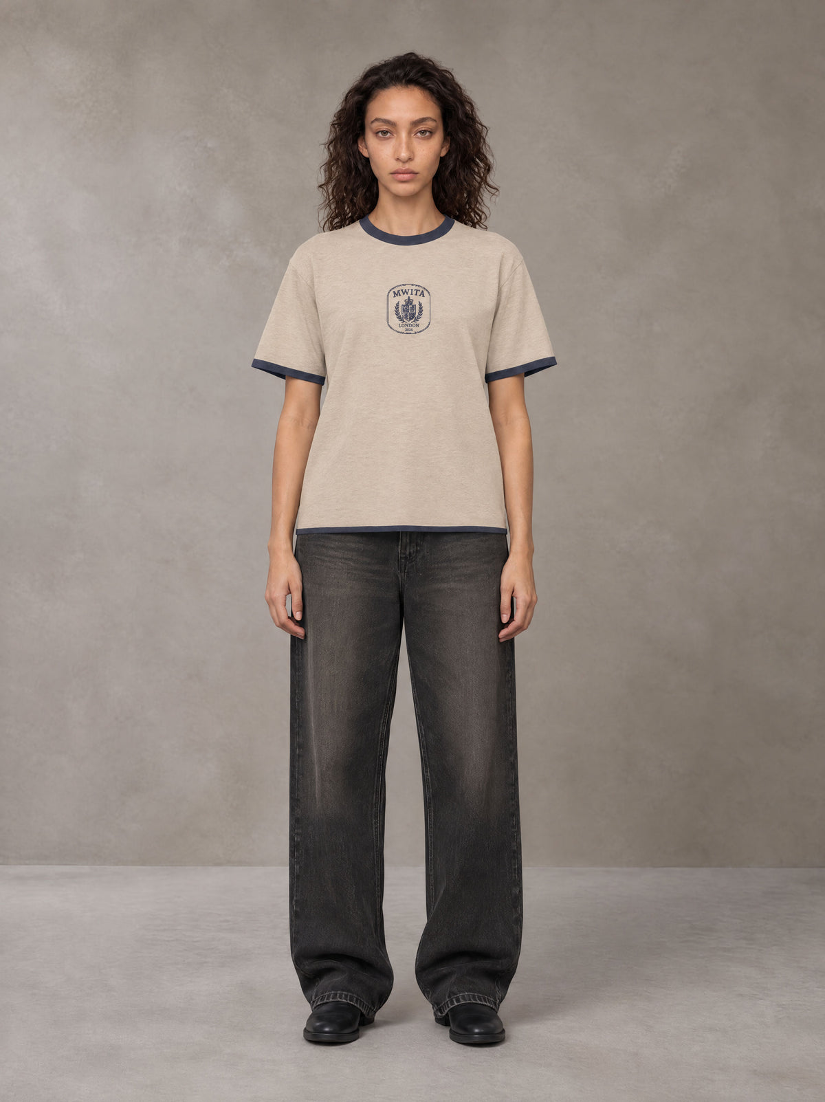 Model wearing the SM Jacquard Knitted Royal Emblem Knitted T-shirt in Oatmeal Cookie, front view.