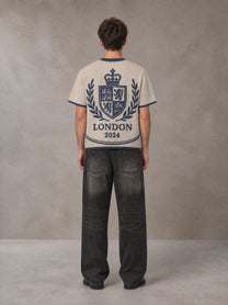 Model wearing the SM Jacquard Knitted Royal Emblem Knitted T-shirt in Oatmeal Cookie, rear view.