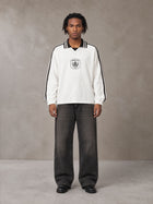 Model wearing the SM Royal Emblem Panel Sweatshirt in Lucent White, front view.
