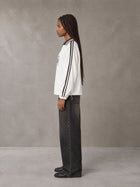 Model wearing the SM Royal Emblem Panel Sweatshirt in Lucent White, side profile.