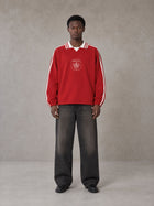 Model wearing the SM Royal Emblem Panel Sweatshirt in Crimson, front view.