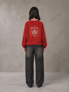Model wearing the SM Royal Emblem Panel Sweatshirt in Crimson, rear view.