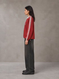 Model wearing the SM Royal Emblem Panel Sweatshirt in Crimson, side profile.