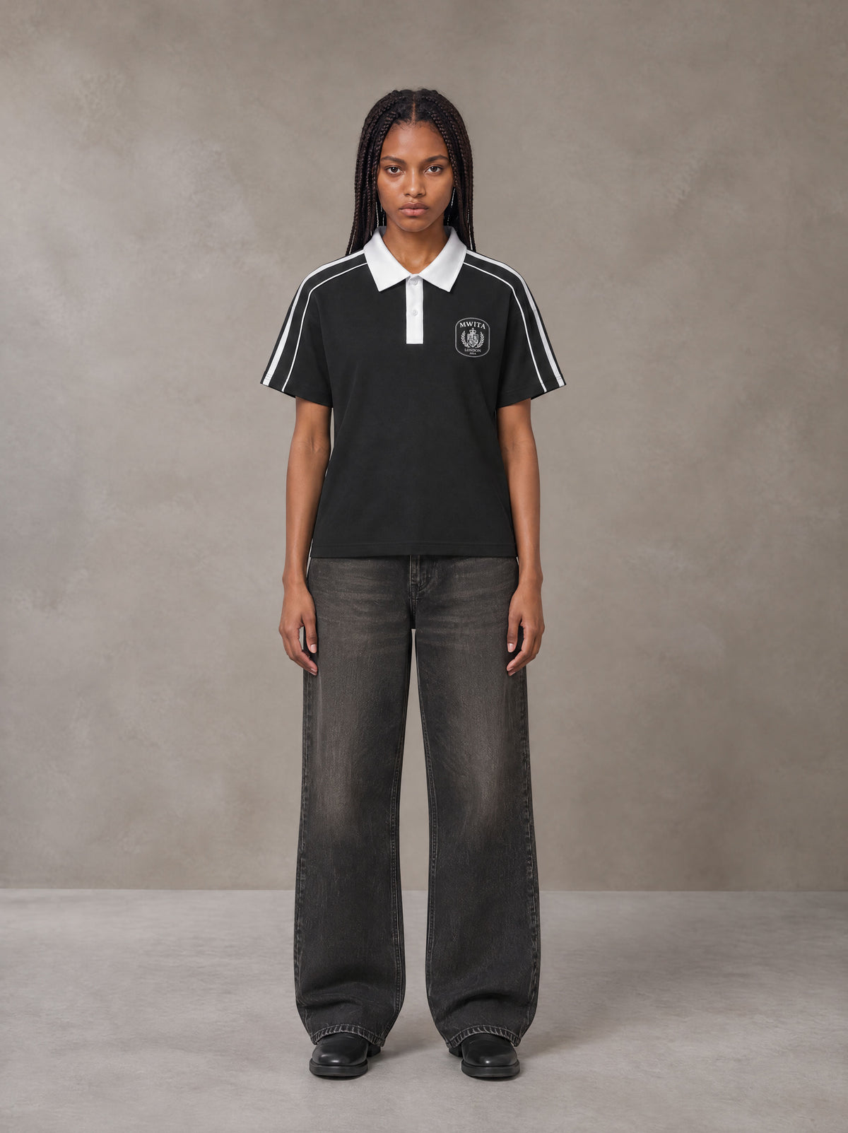 Model wearing the SM Royal Emblem Polo T-shirt in Midnight Black, front view.