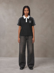 Model wearing the SM Royal Emblem Polo T-shirt in Midnight Black, front view.