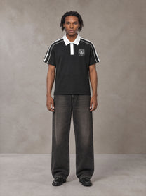 Model wearing the SM Royal Emblem Polo T-shirt in Midnight Black, front view.