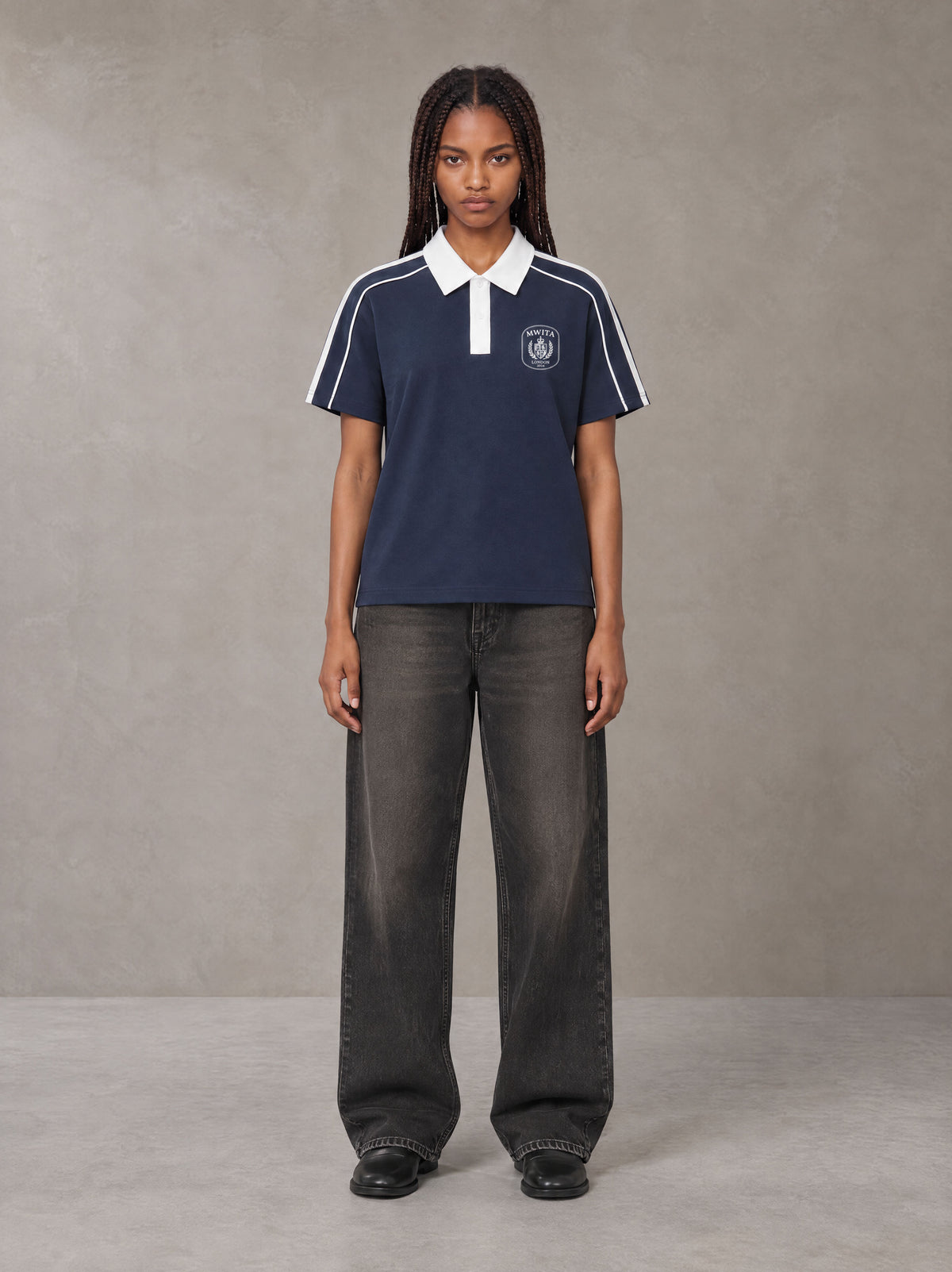 Model wearing the SM Royal Emblem Polo T-shirt in Oxford Navy, front view.