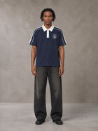 Model wearing the SM Royal Emblem Polo T-shirt in Oxford Navy, front view.