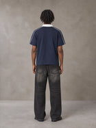 Model wearing the SM Royal Emblem Polo T-shirt in Oxford Navy, rear view.