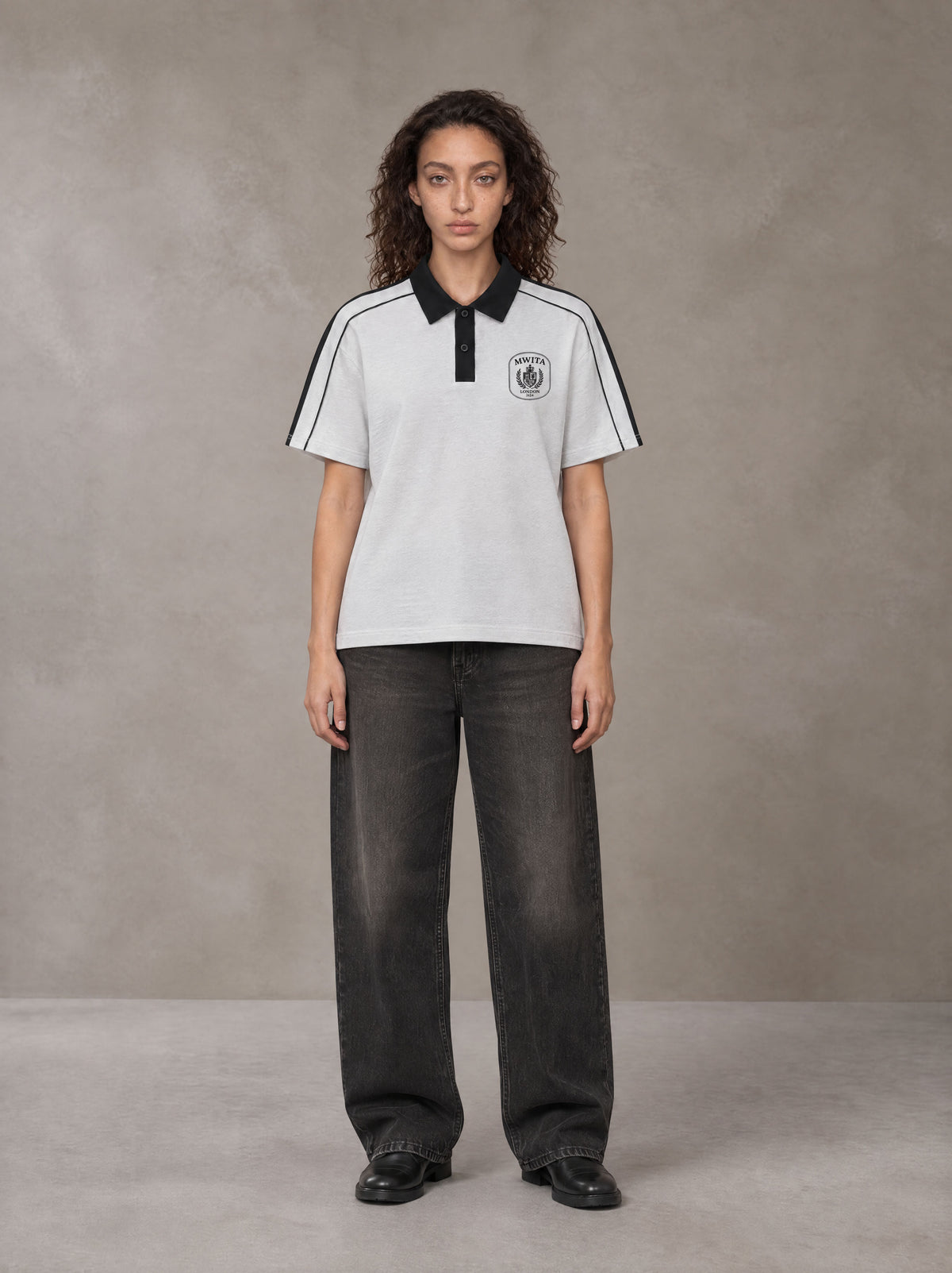 Model wearing the SM Royal Emblem Polo T-shirt in Floral Grey, front view.