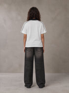 Model wearing the SM Royal Emblem Polo T-shirt in Floral Grey, rear view.
