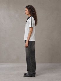 Model wearing the SM Royal Emblem Polo T-shirt in Floral Grey, side profile.