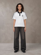 Model wearing the SM Royal Emblem Polo T-shirt in Lucent White, front view.