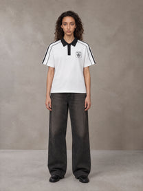 Model wearing the SM Royal Emblem Polo T-shirt in Lucent White, front view.